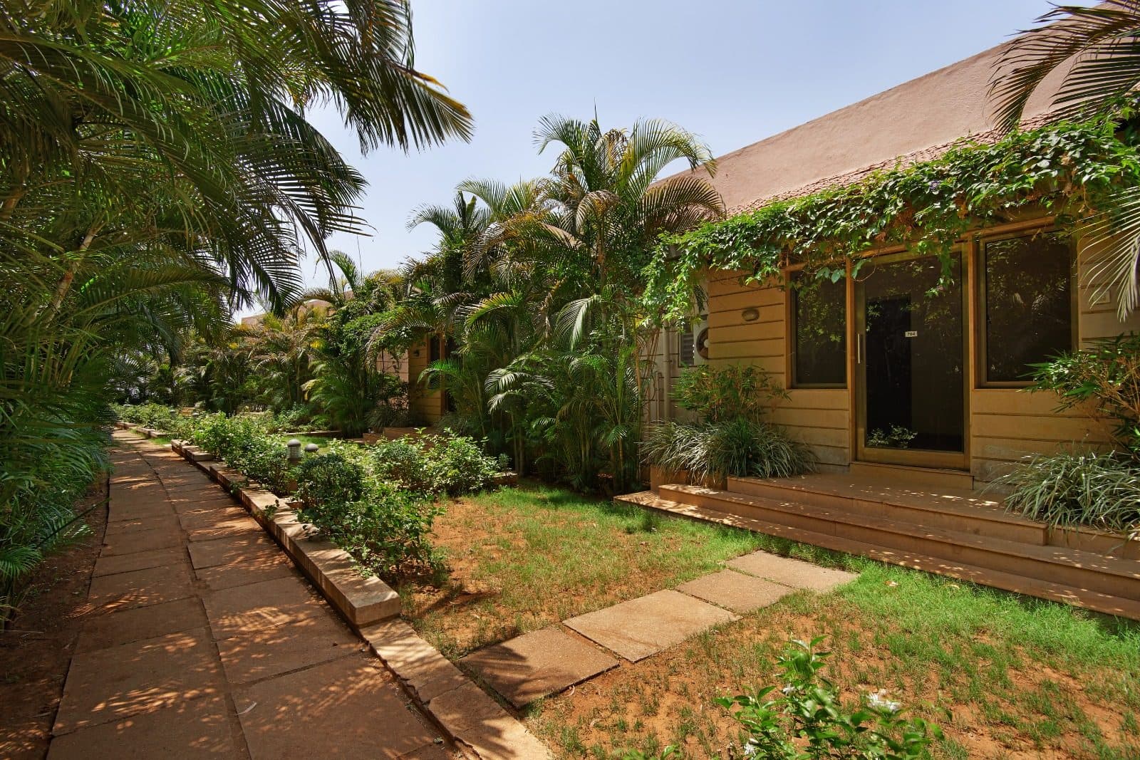Resort Grounds — Cottage Garden Walkway Tropical Palms Bright