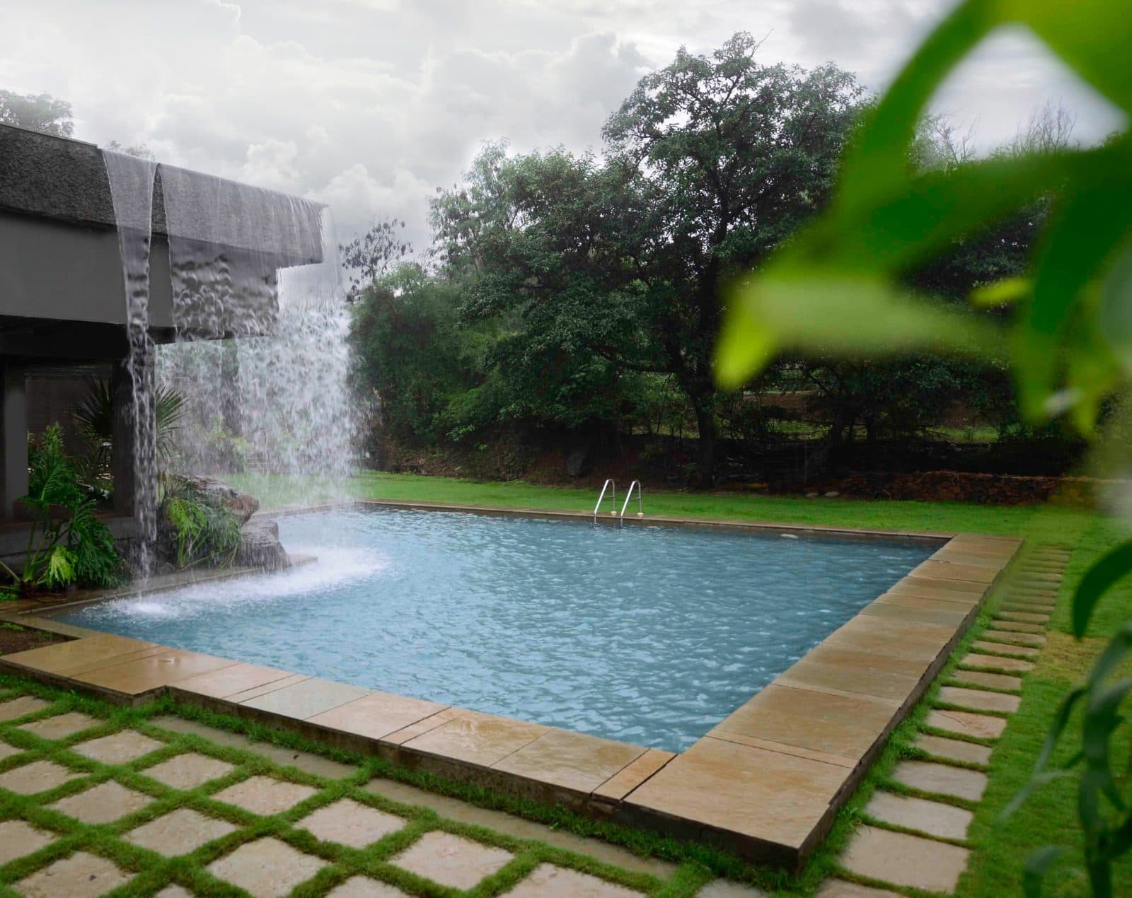 Infinity Pool — Poolside Waterfall Lush Garden Monsoon